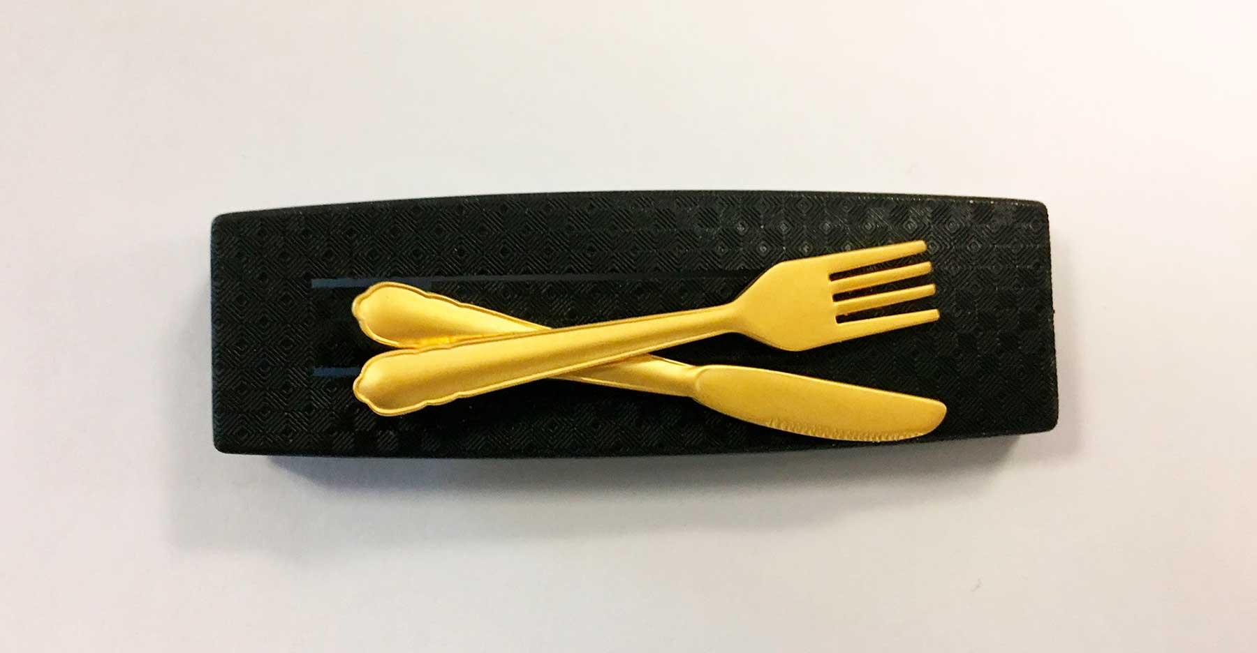 Pin with shiny gold-colored knife and fork