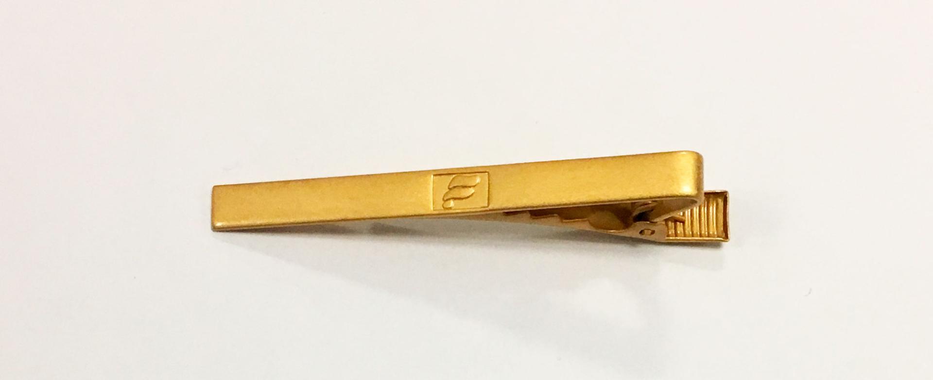 Gold-colored tie clip for Icelandair